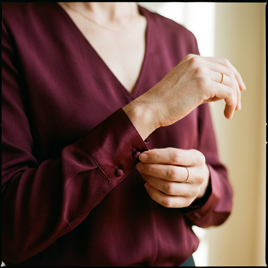 Main ajustant la manchette d’une blouse en satin